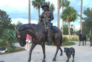 Statue of a man riding a horse next to his dog in the villages florida